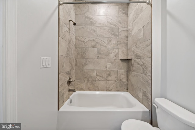 bathroom featuring toilet and tiled shower / bath