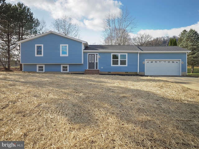 tri-level home with a garage and a front lawn