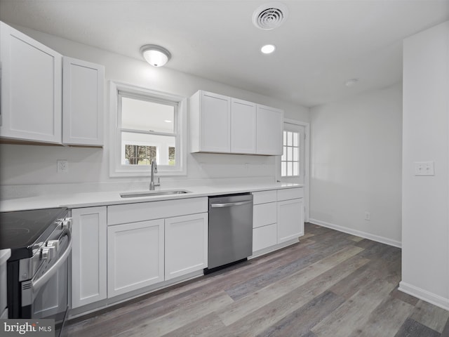 kitchen featuring white cabinets, sink, stainless steel appliances, and a wealth of natural light