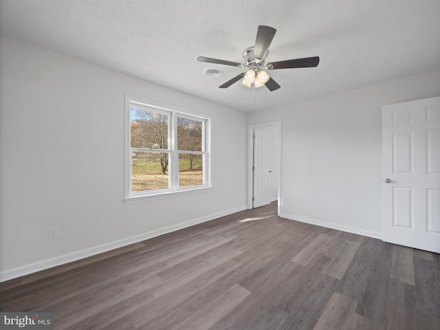 unfurnished room with a textured ceiling, dark hardwood / wood-style flooring, and ceiling fan