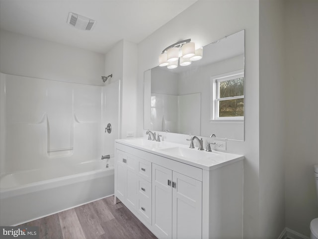 full bathroom with shower / tub combination, toilet, vanity, and hardwood / wood-style flooring