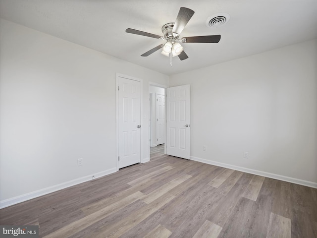 spare room with ceiling fan and light wood-type flooring