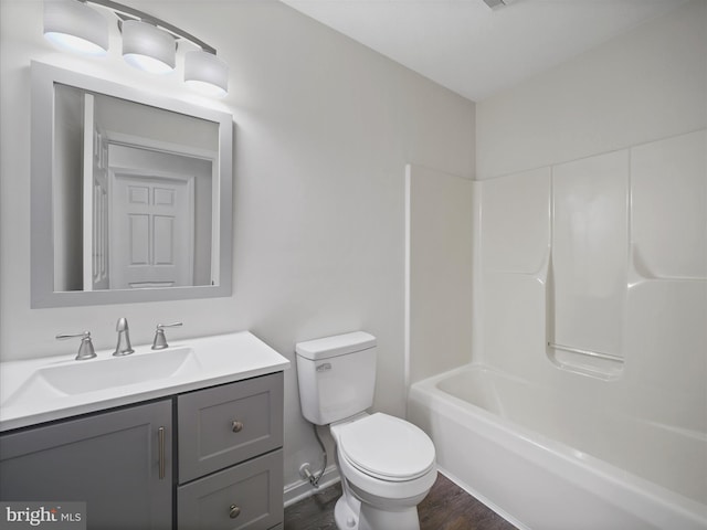 full bathroom featuring washtub / shower combination, hardwood / wood-style floors, vanity, and toilet