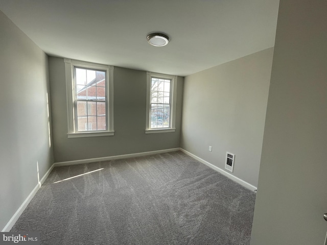 empty room featuring dark carpet