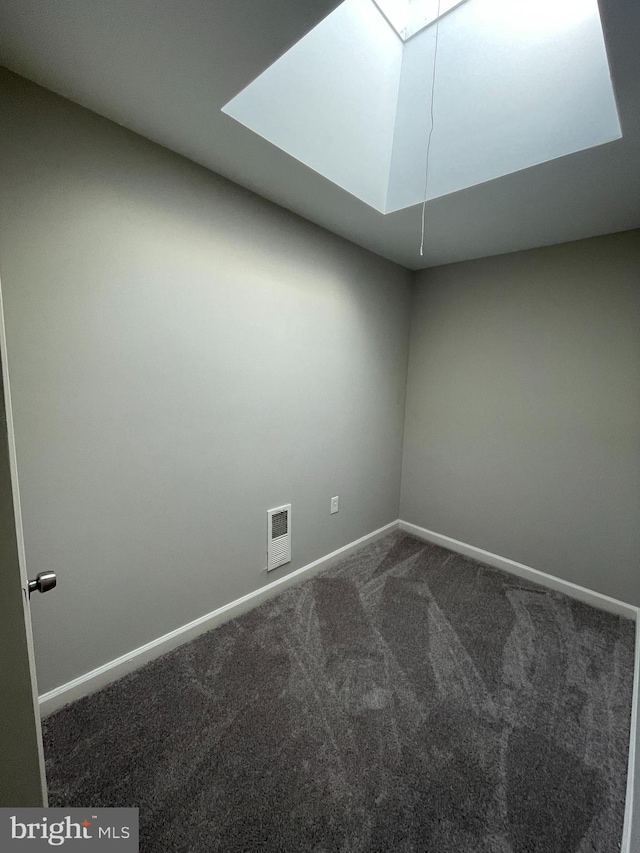 unfurnished room featuring dark colored carpet