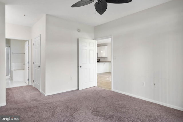 unfurnished bedroom with ensuite bathroom, light colored carpet, and ceiling fan