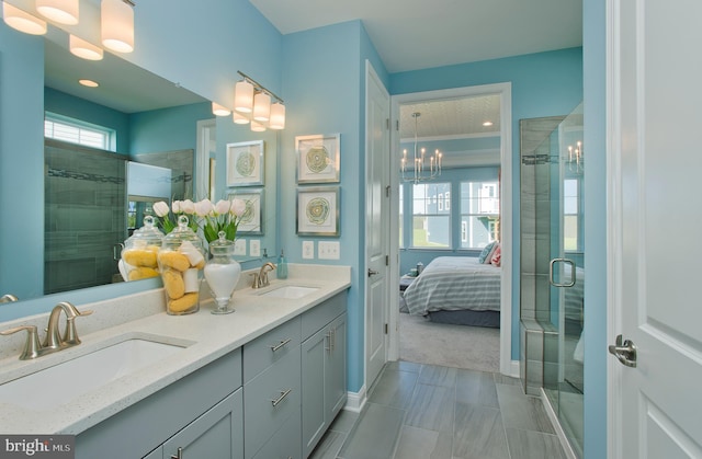 bathroom featuring a chandelier, vanity, and an enclosed shower