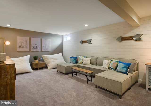 carpeted living room featuring beam ceiling