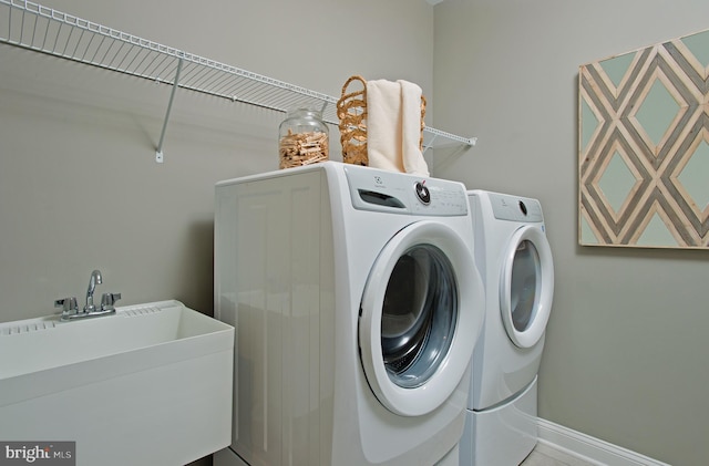 washroom featuring washing machine and dryer and sink