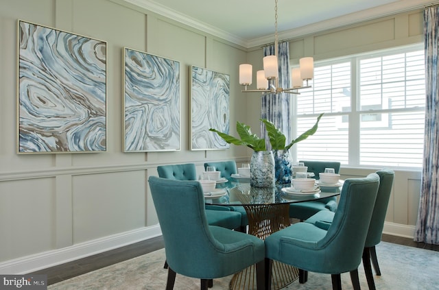 dining area with wood-type flooring, plenty of natural light, a notable chandelier, and ornamental molding