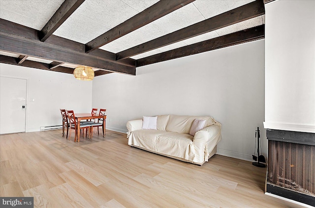 living area featuring radiator, beamed ceiling, light hardwood / wood-style flooring, and a baseboard heating unit