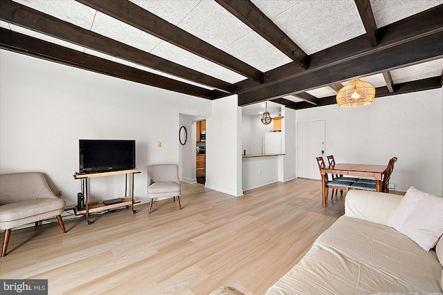 living room with light hardwood / wood-style flooring and beam ceiling