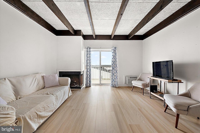 living room with light hardwood / wood-style flooring, an AC wall unit, and beam ceiling