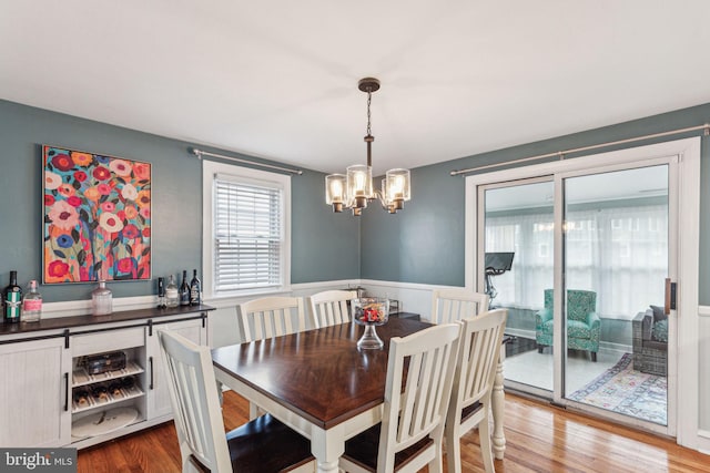 dining space featuring hardwood / wood-style floors and a notable chandelier