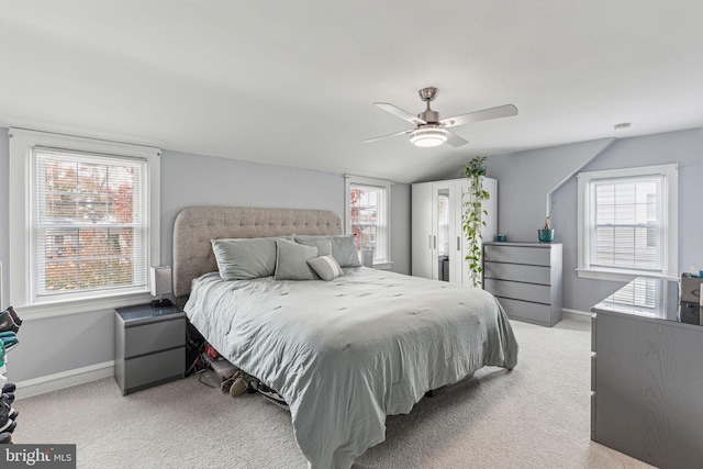 bedroom with multiple windows, ceiling fan, and light colored carpet