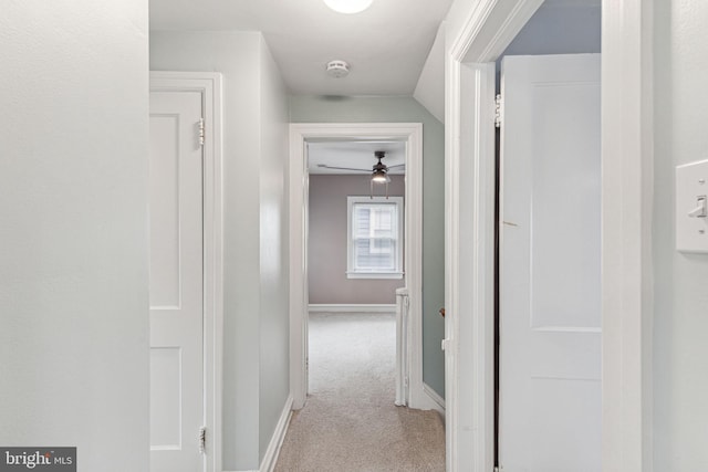 corridor with light carpet and vaulted ceiling