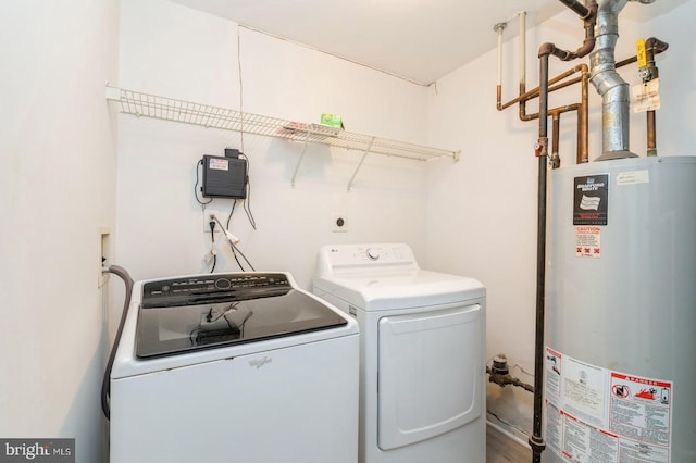 washroom with wood-type flooring, gas water heater, and washer and dryer