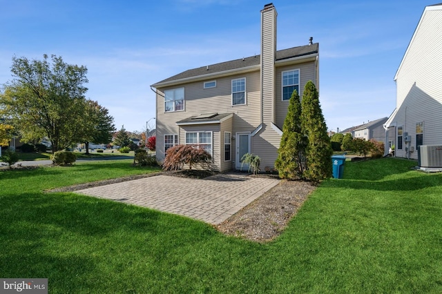 rear view of property with central AC unit, a lawn, and a patio