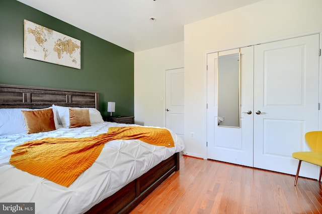 bedroom with light hardwood / wood-style floors and a closet