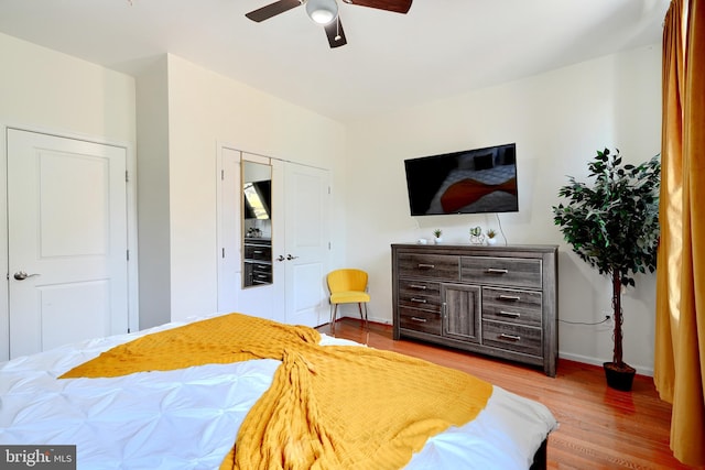 bedroom featuring hardwood / wood-style flooring, ceiling fan, and a closet