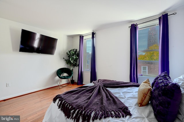 bedroom featuring hardwood / wood-style floors and multiple windows