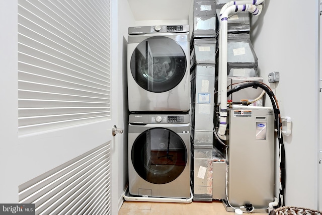 washroom with stacked washer and clothes dryer and light tile patterned floors