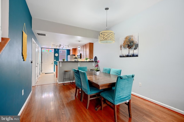 dining room with light wood-type flooring and track lighting