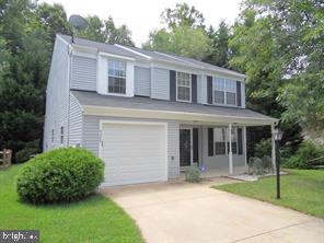 view of front of home with concrete driveway, an attached garage, and a front lawn