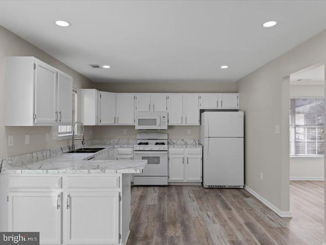 kitchen featuring white appliances, a sink, and white cabinets