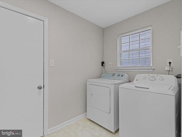 laundry area with laundry area, baseboards, washer and clothes dryer, and light floors