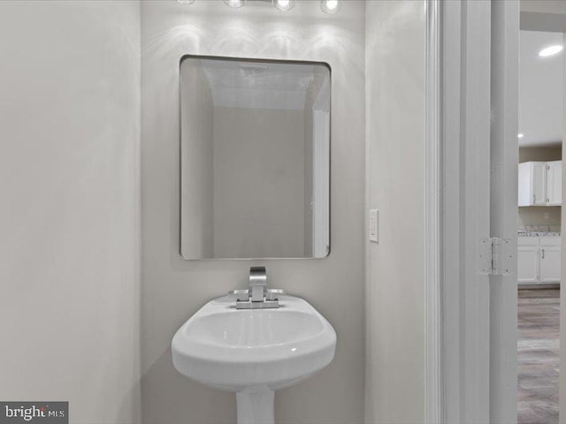 bathroom with a sink and wood finished floors