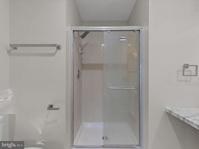 bathroom featuring a shower stall and toilet