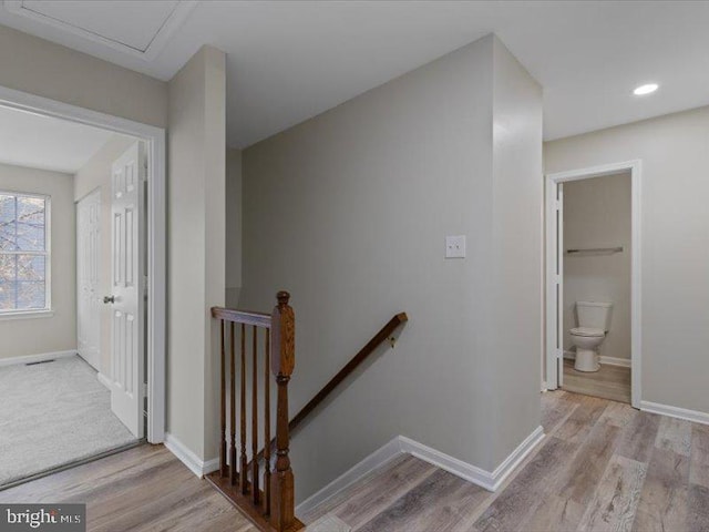 stairway with wood finished floors and baseboards