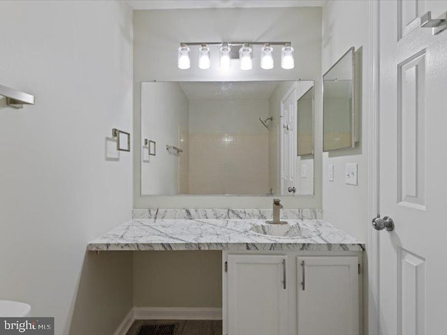 full bathroom featuring tiled shower and vanity