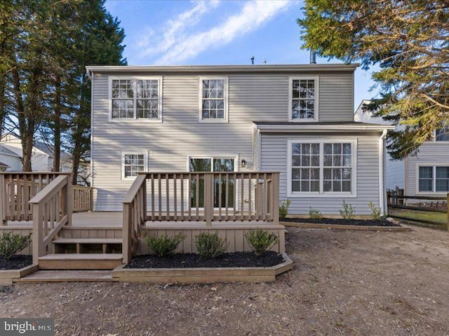 back of property with fence and a wooden deck