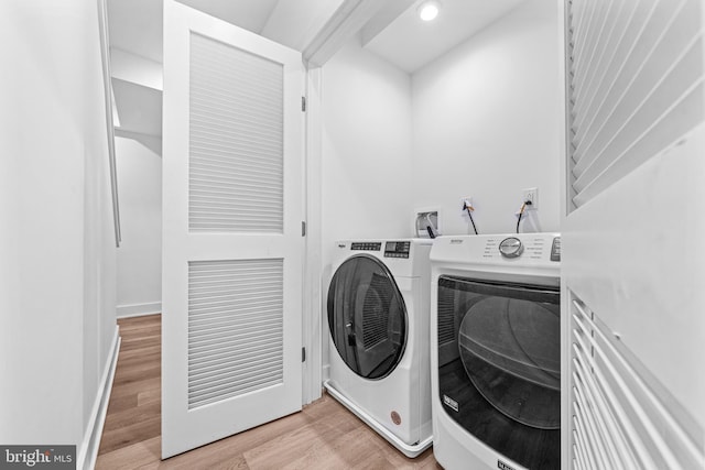 laundry area featuring light hardwood / wood-style floors and washing machine and clothes dryer