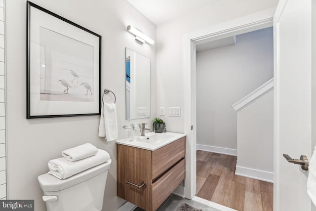 bathroom featuring hardwood / wood-style flooring, vanity, and toilet