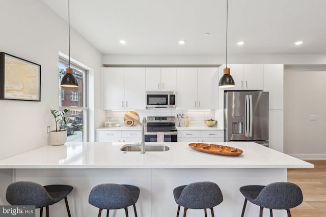 3205 N 35th St Unit 5, Philadelphia, PA 19129 - kitchen featuring stainless steel appliances, a breakfast bar area, light wood-type flooring, backsplash, and recessed lighting