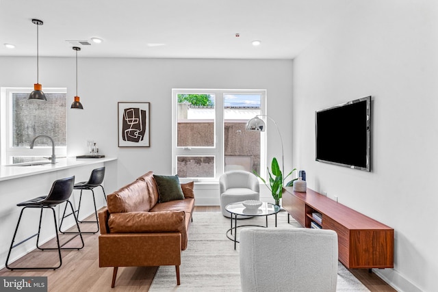 living room with sink and light wood-type flooring