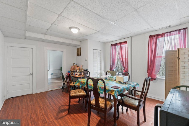 dining area featuring a paneled ceiling and wood-type flooring