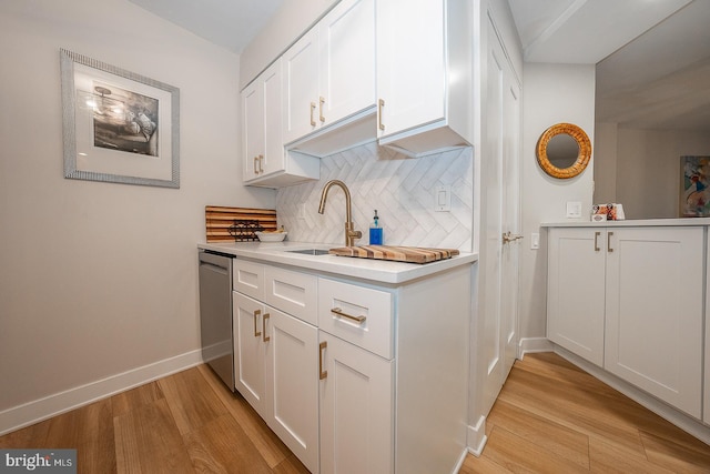 kitchen featuring white cabinetry, dishwasher, and backsplash