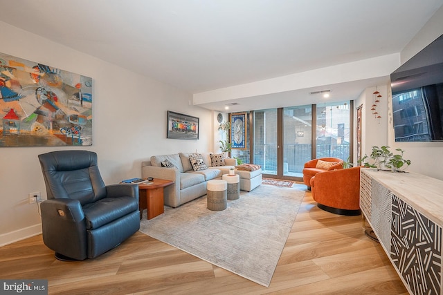 living room featuring floor to ceiling windows and light wood-type flooring