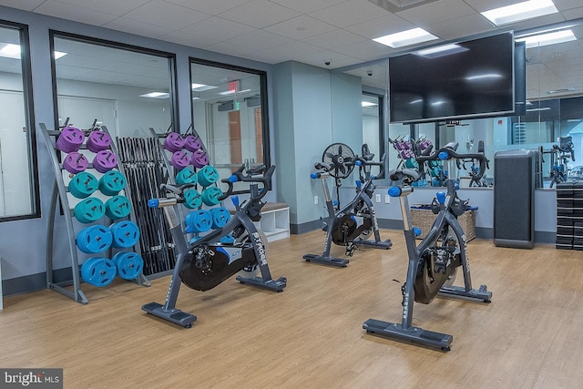 workout area featuring a drop ceiling and wood-type flooring