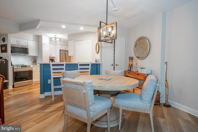 dining area with a chandelier and light hardwood / wood-style flooring