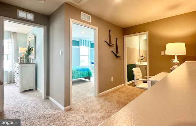 hallway with a wealth of natural light and light carpet