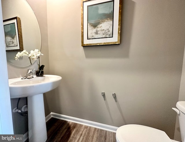 bathroom featuring toilet and wood-type flooring