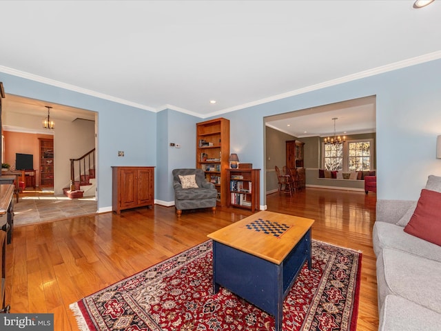 living room with ornamental molding, a chandelier, and hardwood / wood-style floors