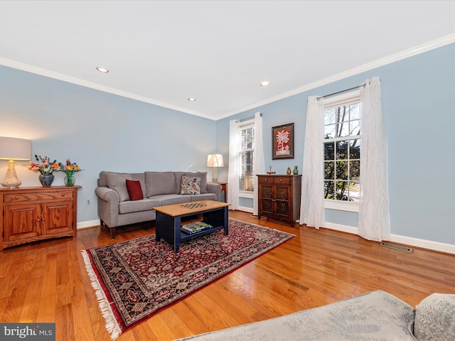 living room with hardwood / wood-style flooring and crown molding