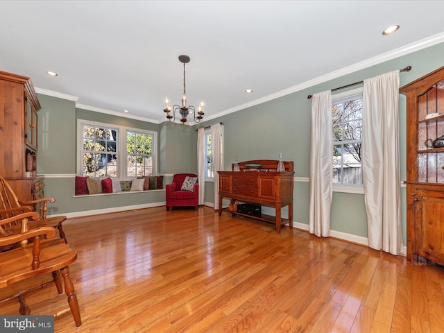 sitting room with crown molding, a chandelier, and light wood-type flooring