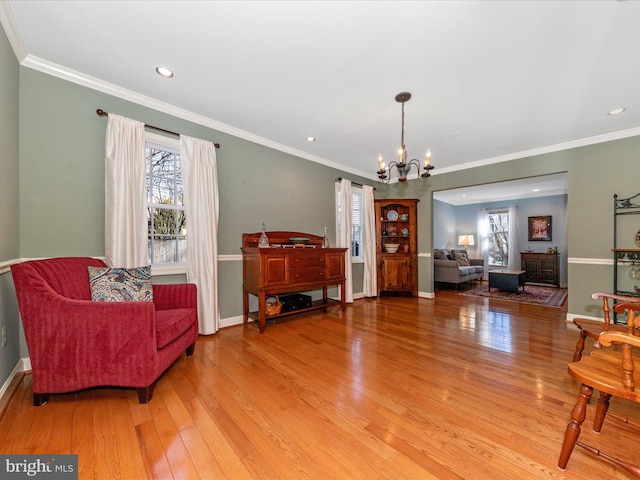 living area featuring ornamental molding, a chandelier, and hardwood / wood-style floors